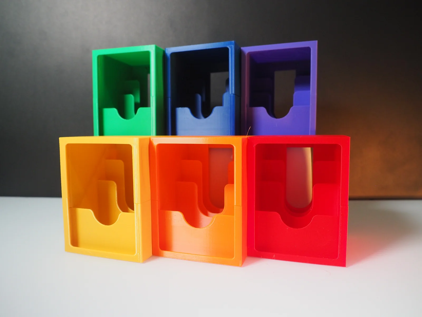 Riftbound deckboxes in green, blue, purple, yellow, orange, and red